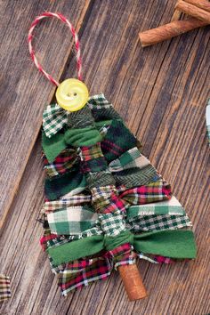 a christmas tree made out of plaid fabric and a button on the top is sitting on a wooden table