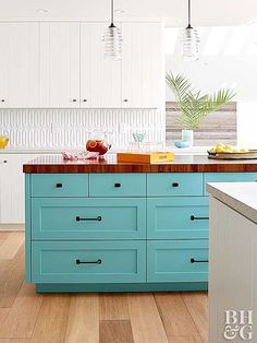 a kitchen with white cabinets and blue drawers