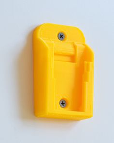 a yellow plastic object on a white surface