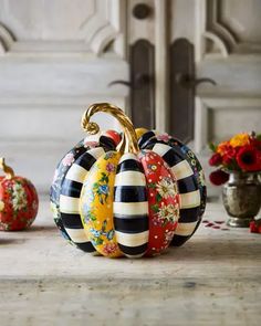 three decorative pumpkins sitting on top of a table