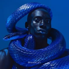 a man with blue snakes around his neck and head, in front of a blue background