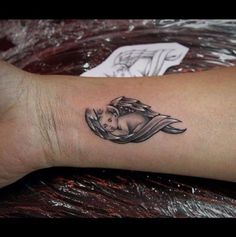 a woman's arm with a small tattoo on it