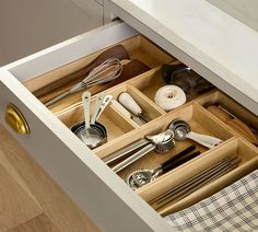 an open drawer with utensils in it