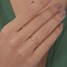 a woman's hand with a diamond ring on her left hand, wearing a green dress