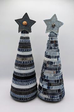 two decorative christmas trees made out of old jeans and other material, each with a star on top