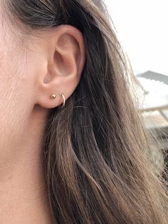 a close up of a person wearing a pair of ear piercings on their ears