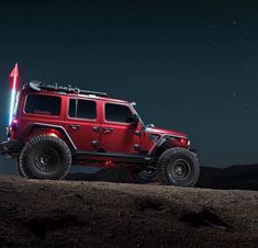 a red jeep parked on top of a hill at night