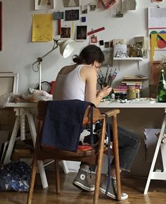 a woman sitting at a desk in an art studio