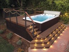 an outdoor hot tub with stairs and lights