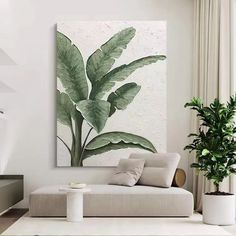 a living room with a couch, coffee table and potted plant on the wall