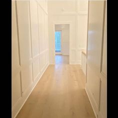 an empty room with white walls and wood floors is seen in this image taken from the hallway