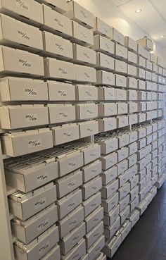 many boxes are stacked on the wall in an office building with wood floors and white walls