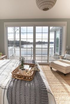 a bed sitting in a bedroom next to a sliding glass door with a basket on top of it