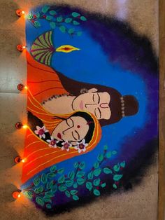 a painting on the ground with lights around it and a woman holding a man's head