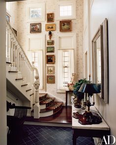 an entry way with stairs and pictures on the wall