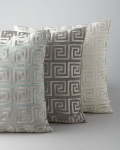 three decorative pillows sitting on top of each other