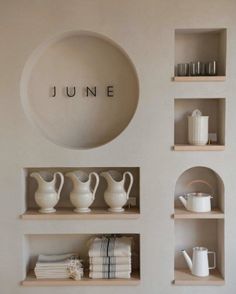 the shelves are filled with white dishes and cups, along with some books on them