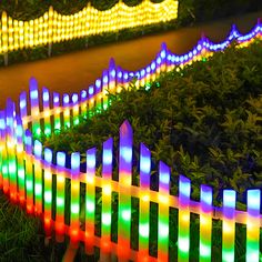 colorful lights are lit up on a fence