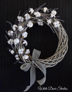 a wreath with cotton and ribbon hanging on a wall