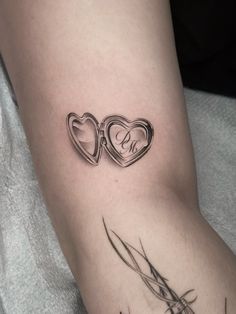 a couple of hearts tattoo on the left side of the arm, with two initials in them