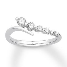 a white gold ring with three diamonds on it's sides and the band in the shape of a wave