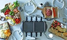 a table topped with plates and utensils filled with different types of food next to each other