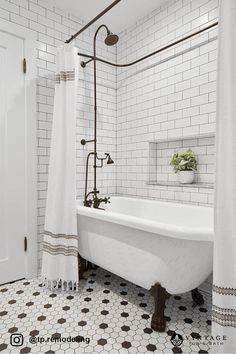 a white bath tub sitting next to a shower in a bathroom with black and white tile