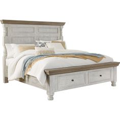 a white bed with drawers underneath it and a blanket on the top of the bed