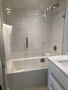 a white bathroom with a glass shower door