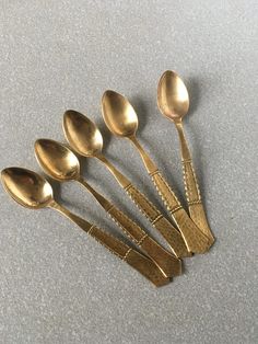 five gold spoons sitting next to each other on a table