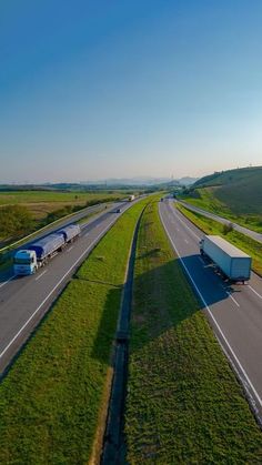 two semi trucks driving down the highway next to each other on either side of one another