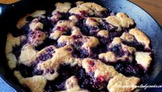 blueberry cobbler in a cast iron skillet ready to be eaten and served