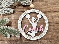 a christmas ornament with the word coach on it and a cheerleader holding pom poms