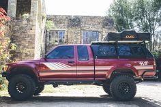 a red pick up truck parked in front of a house