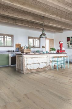 a large kitchen with wooden floors and white walls is featured in this ad for flooring