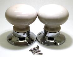 two white knobs with screws on top of them