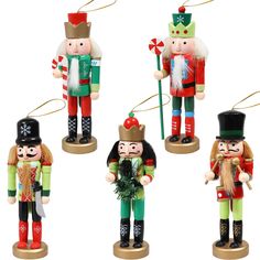 four wooden nutcrackers are shown in different colors and sizes, each with a green hat