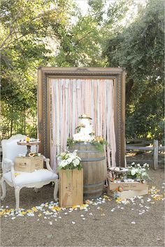 an outdoor ceremony area with a barrel and flowers on the ground next to a chair