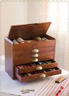 a wooden box with drawers filled with different types of items