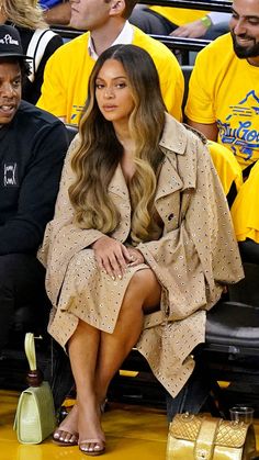 the woman is sitting on the bench at a basketball game