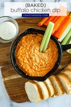 baked buffalo chicken dip with sliced carrots and celery on a cutting board