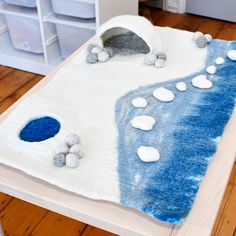 a child's bed made out of felt and rocks