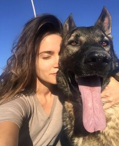 a woman with her tongue hanging out next to a dog