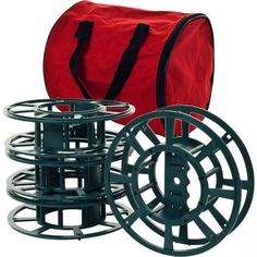 a red bag sitting next to two reels and some black plastic discs on a white background