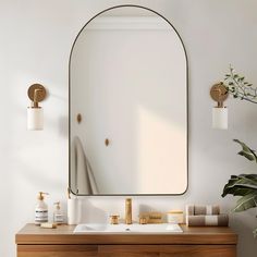 a bathroom vanity with a large mirror above it and gold faucets on the wall