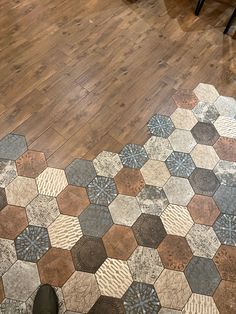 a person standing on the floor in front of a wooden floor with hexagonal tiles