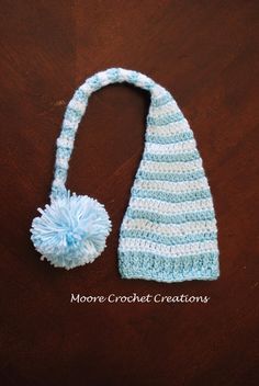 a crocheted blue and white hat with a pom - pom on it