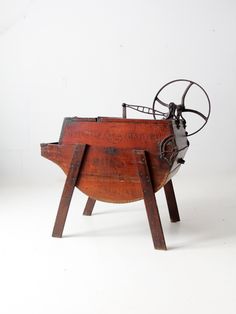 an old fashioned machine sitting on top of a wooden stand