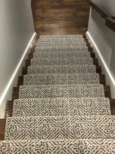 a carpeted staircase with wooden handrails and white walls