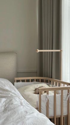 a baby crib next to a window with curtains